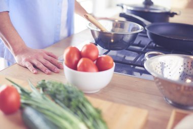 Adam ev mutfağında lezzetli ve sağlıklı yemekler hazırlıyor.