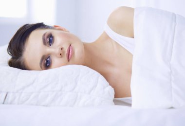 Genç ve güzel bir kadın yatakta yatıyor..