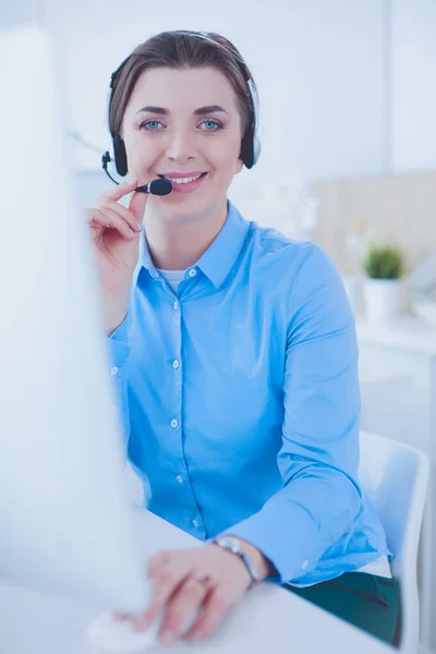 Seriös söt ung kvinna som arbetar som support telefonoperatör med headset i ämbetet — Stockfoto