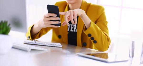 Retrato de empresária usando telefone celular e mensagens de texto enquanto se senta na mesa na frente do laptop — Fotografia de Stock