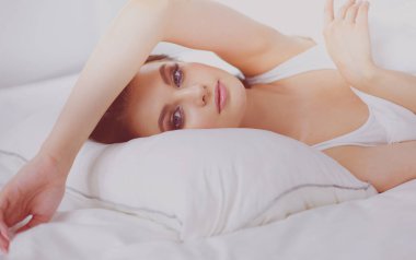 Genç ve güzel bir kadın yatakta yatıyor..