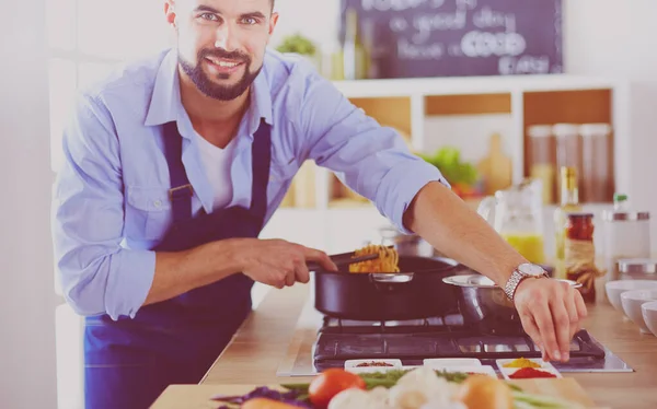 Mann folgt Rezept auf digitalem Tablet und kocht leckeres und gesundes Essen in der heimischen Küche — Stockfoto