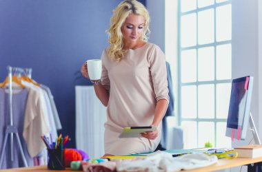 Moda tasarımcısı kadın stüdyoda tasarımları üzerinde çalışıyor..