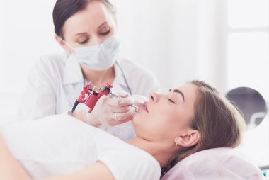 Kırmızı dudaklı genç bir kız kalıcı makyaj, mikro pigmentasyon