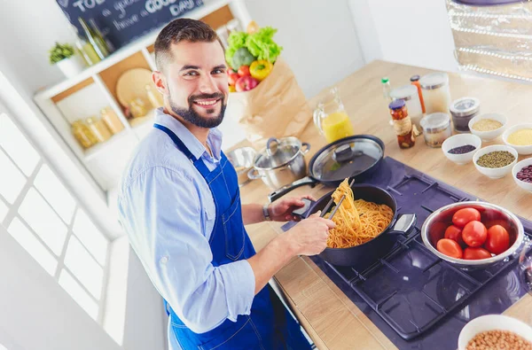 Człowiek przygotowuje pyszne i zdrowe jedzenie w kuchni domowej — Zdjęcie stockowe