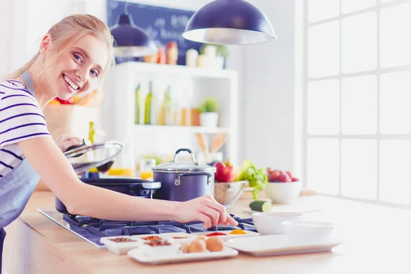 Schöne junge Frau kocht zu Hause in der Küche — Stockfoto