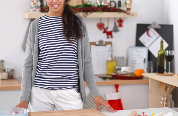 Sorrindo jovem mulher de pé na cozinha — Fotografia de Stock