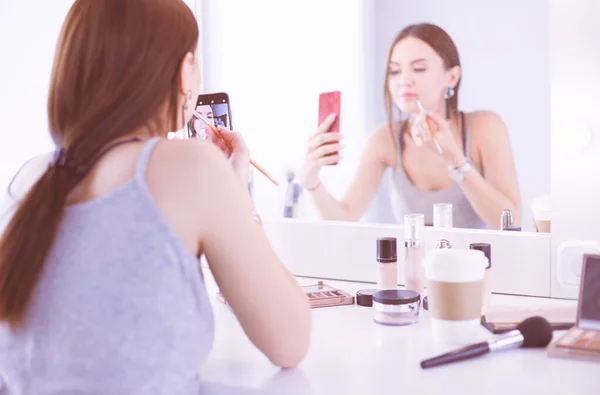 Blogger pro krásu filmování s smartphone před zrcadlem — Stock fotografie