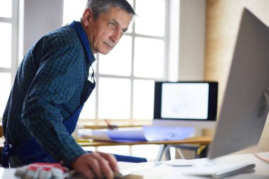 Ofisteki çizim masasında çalışan mimar