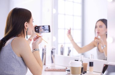 Ayna önünde akıllı telefon ile makyaj eğitimi filme Güzellik blogger