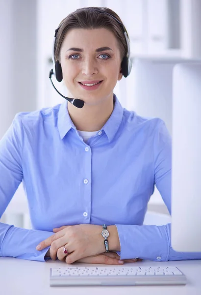 Ernstige mooie jonge vrouw die werkt als support telefoon operator met headset in het kantoor — Stockfoto