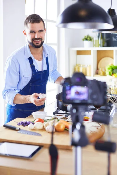 Man som håller papperspåse full av matvaror på köksbakgrund. Shopping och hälsosam mat koncept — Stockfoto