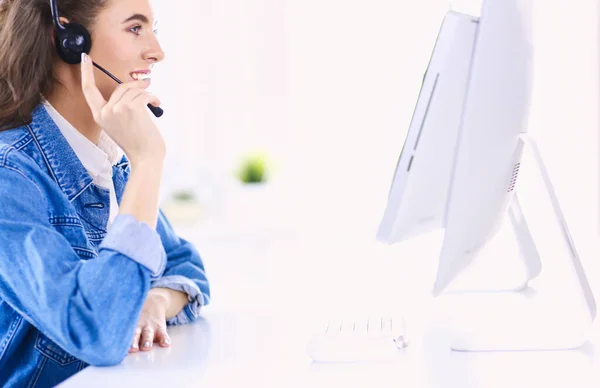 Retrato de mulher de negócios bonita trabalhando em sua mesa com fone de ouvido e laptop — Fotografia de Stock