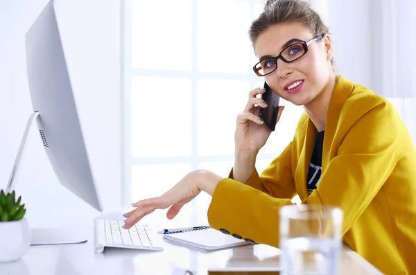 Empresaria concentrándose en el trabajo, usando computadora y celular en la oficina — Foto de Stock