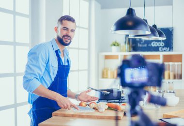 Mutfak arka planında poşet dolusu erzak tutan adam. Alışveriş ve sağlıklı gıda konsepti