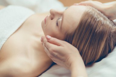 Spa salonunda güzel bir kadının resmi.