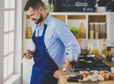 Mutfak arka planında poşet dolusu erzak tutan adam. Alışveriş ve sağlıklı gıda konsepti