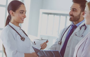 Bayan bir doktor başka bir doktora ofisinde röntgen gösteriyor.