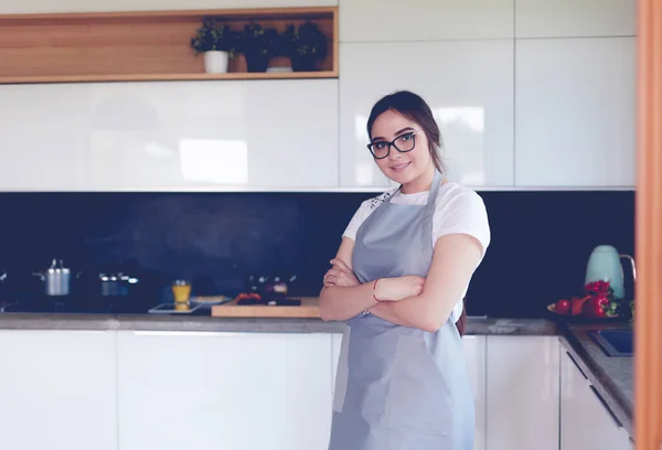 Portré fiatal nő álló karokkal keresztbe konyha háttér — Stock Fotó