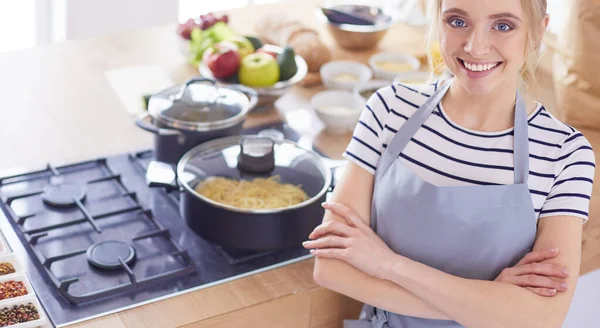 Jonge vrouw in de buurt van bureau in de keuken — Stockfoto