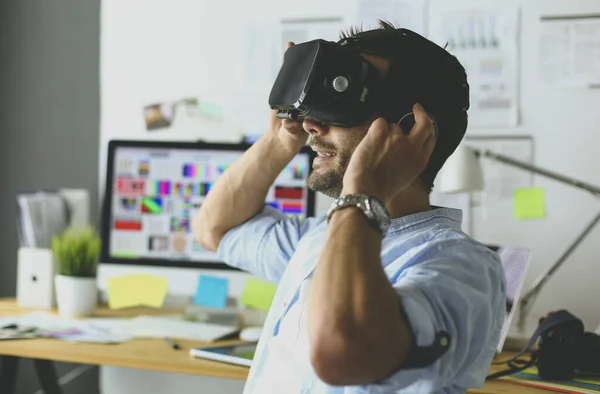 Jovem programador de software masculino testando um novo aplicativo com óculos de realidade virtual 3d no escritório . — Fotografia de Stock