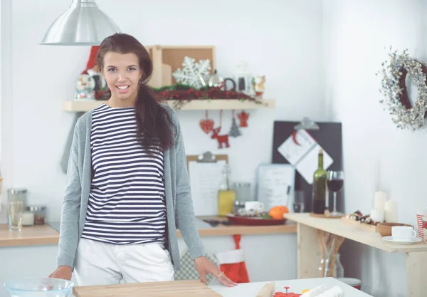 Усміхнена молода жінка стоїть на кухні — стокове фото