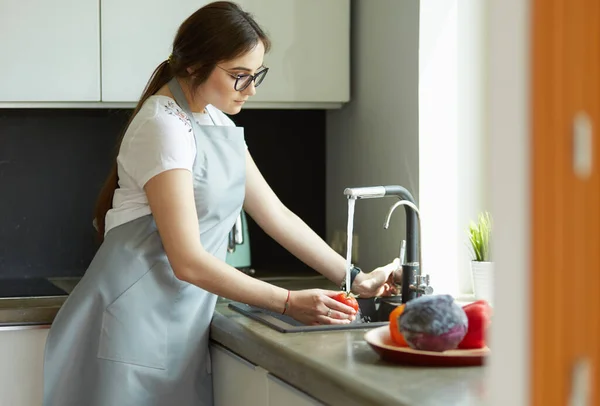 Mãos de mulher lavando legumes em sua cozinha — Fotografia de Stock