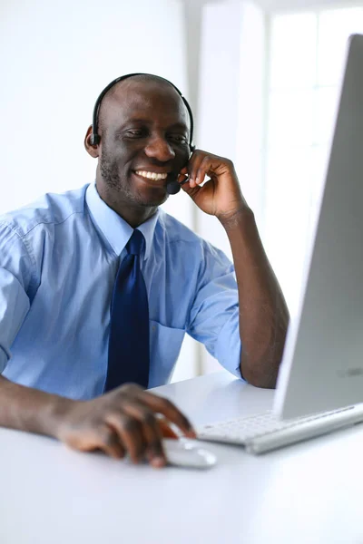 African american businessman on headset working on his laptop — Stock Photo, Image