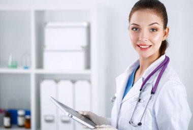 Kadın doktor hastanede dosyayla bekliyor.