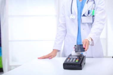 Doktor ödeme terminalini elinde tutuyor. Sağlık hizmetlerinin parasını ödüyorum. Doktor.