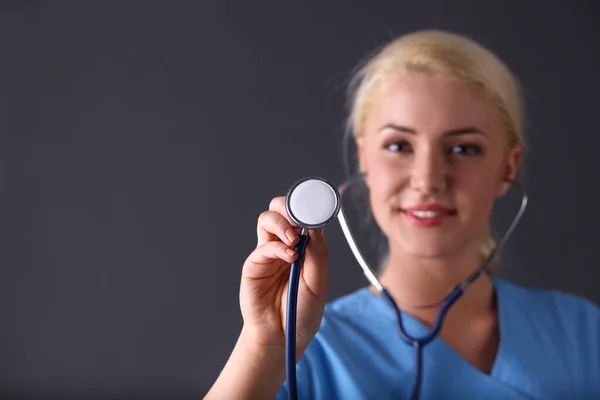 Femme médecin avec un stéthoscope à l'écoute, isolée sur fond gris — Photo