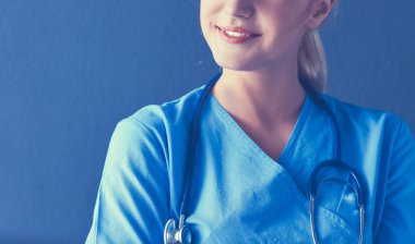 Steteskoplu genç doktor kadın gri arka planda izole edilmiş.