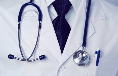 Genç doktor ofisinde oturuyor ve röntgen sonuçlarını inceliyor.