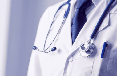 Genç doktor ofisinde oturuyor ve röntgen sonuçlarını inceliyor.