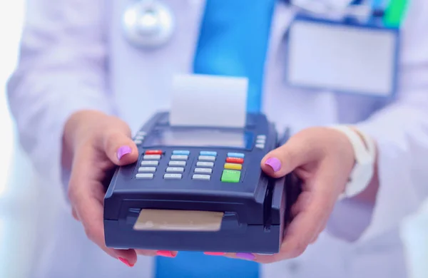 Le docteur tient le terminal de paiement entre les mains. Payer pour les soins de santé. Docteur. — Photo