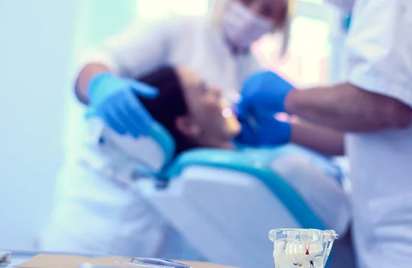 Porträtt av en tandläkare som behandlar tänder av ung kvinna patient — Stockfoto