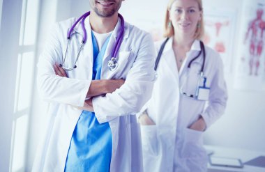 Genç ve kendinden emin doktorların portresi tıp ofisinde duruyor.