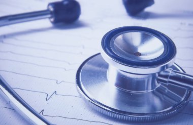 Masada yatan elektrokardiyogramda stetoskop.