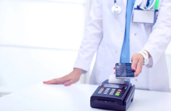 Le docteur tient le terminal de paiement entre les mains. Payer pour les soins de santé. Docteur. — Photo