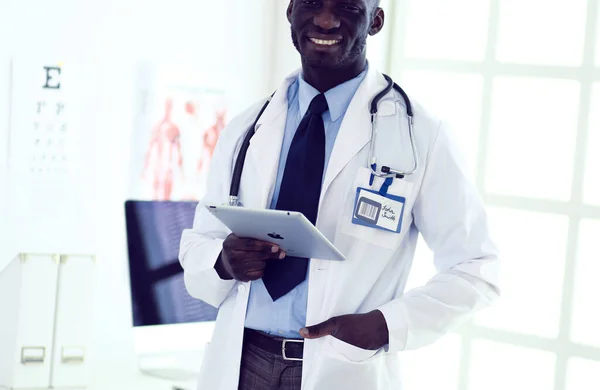 Male black doctor worker with tablet computer standing in hospital — Stock Photo, Image