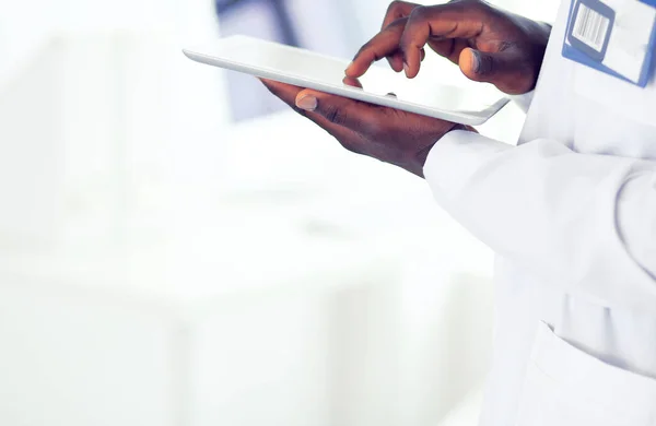 Male black doctor worker with tablet computer standing in hospital — Stock Photo, Image