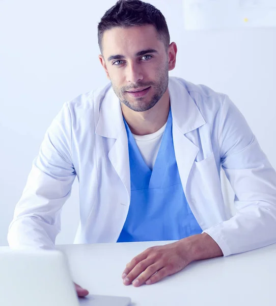 Portret van een mannelijke arts met laptop aan het bureau in medisch kantoor — Stockfoto