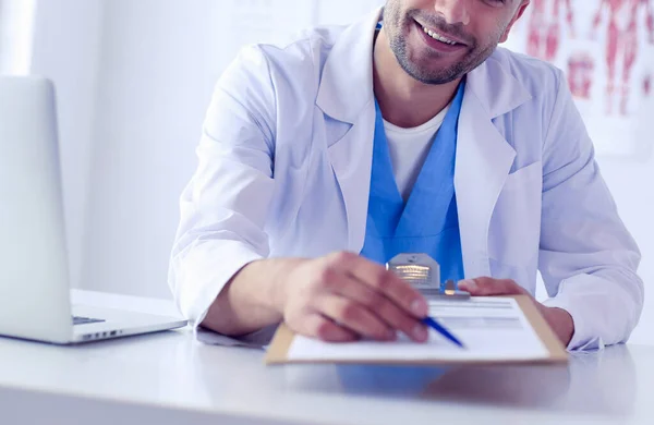 Männlicher Arzt sitzt mit Laptop am Schreibtisch — Stockfoto