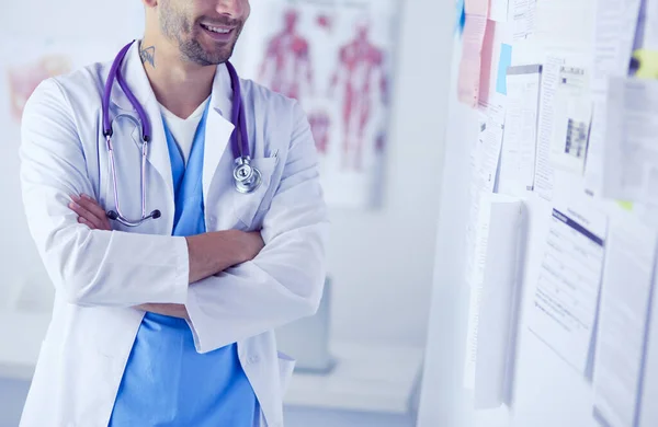 Mladý a sebevědomý mužský lékař portrét stojící v lékařské ordinaci. — Stock fotografie