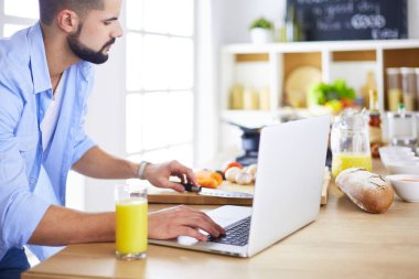 Adam ev mutfağında lezzetli ve sağlıklı yemekler hazırlıyor.