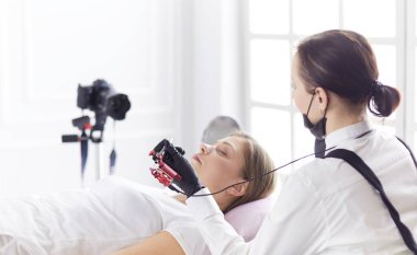 Güzellik salonunda kaş makyajı yapılan genç bir kadın.