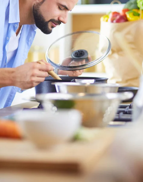 デジタルタブレット上のレシピに従う男と自宅でキッチンでおいしいと健康食品を調理 — ストック写真