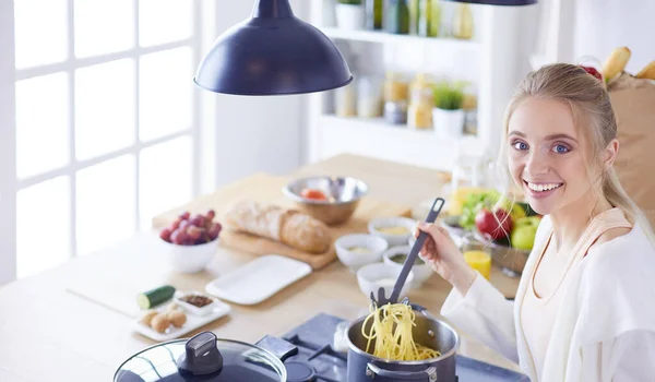 Beautiful young woman cooking in kitchen at home — Stock Photo, Image