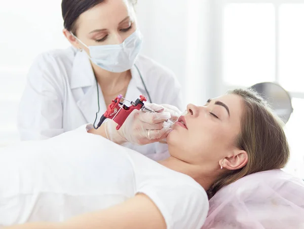 A young girl having red lips permanent makeup, micropigmentation — Stock Photo, Image