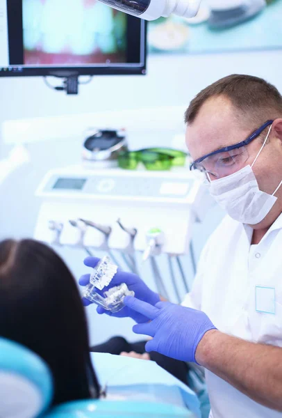 Portrait of a dentist who treats teeth of young woman patient — Stock Photo, Image